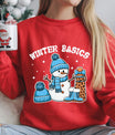 Red sweatshirt featuring a cheerful snowman in blue winter gear with a leopard-print gift and the phrase “Winter Basics” above.