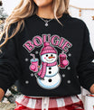 Black sweatshirt featuring a snowman with pink hat, scarf, and gloves, holding drinks with the word “BOUGIE” in bold pink letters.