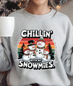 Gray sweatshirt with a retro sunset background featuring three cheerful snowmen and the text “Chillin’ With My Snowmies.”