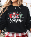 Black sweatshirt featuring a festive snowman and candy-striped “Cozy Season” DTF transfer design with snowflakes, perfect for Christmas and winter-themed apparel.