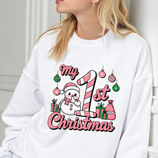 White sweatshirt featuring a pink and green “My 1st Christmas” DTF transfer design with a snowman, candy cane, ornaments, and presents—perfect for baby’s first holiday.