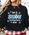 Black sweatshirt with a blue and white “Let It Snow Somewhere Else” DTF design featuring a smiling snowman face with a bow, surrounded by snowflakes, ideal for holiday apparel.