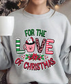 Gray sweatshirt featuring a pink hot cocoa mug with marshmallows and candy cane, surrounded by holly and the text “For the Love of Christmas” in festive red and green.