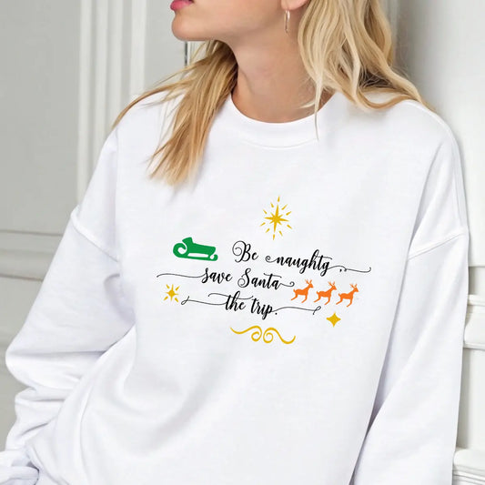 White sweatshirt featuring the phrase “Be Naughty, Save Santa the Trip” in elegant script with green sleigh, orange reindeer, and gold stars—funny minimalist Christmas design.