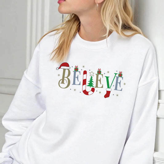 White sweatshirt featuring the word “BELIEVE” decorated with Santa hat, candy cane, Christmas tree, gifts, and stocking—classic festive DTF transfer design.