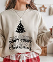 Beige sweatshirt featuring a black Christmas tree and the phrase “Calories Don’t Count During Christmas” in fun festive lettering—perfect for holiday baking apparel.