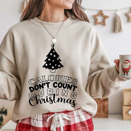 Beige sweatshirt featuring a black Christmas tree and the phrase “Calories Don’t Count During Christmas” in fun festive lettering—perfect for holiday baking apparel.