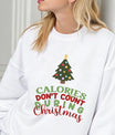 White sweatshirt featuring a decorated Christmas tree and the phrase “Calories Don’t Count During Christmas” in red and green lettering—fun and festive holiday design.