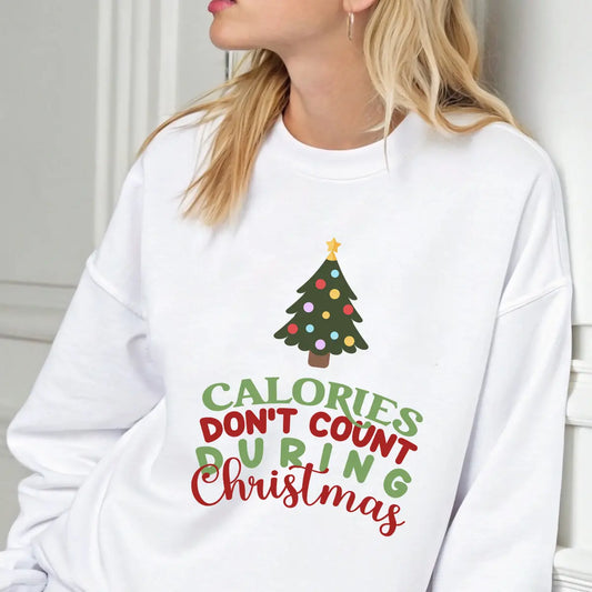 White sweatshirt featuring a decorated Christmas tree and the phrase “Calories Don’t Count During Christmas” in red and green lettering—fun and festive holiday design.