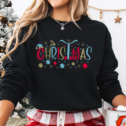 Black sweatshirt featuring colorful “Christmas” DTF design with reindeer, ornaments, snowflakes, and gifts—bright and festive holiday lettering style.