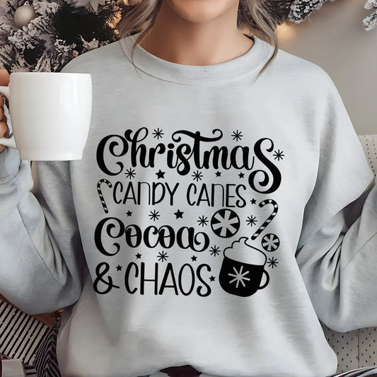 Gray sweatshirt featuring the phrase “Christmas Candy Canes Cocoa & Chaos” in fun black script with stars, candy canes, and a cocoa mug—playful holiday design.