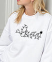 White sweatshirt with DTF design spelling “love” in Christmas light string style, minimalist holiday graphic.