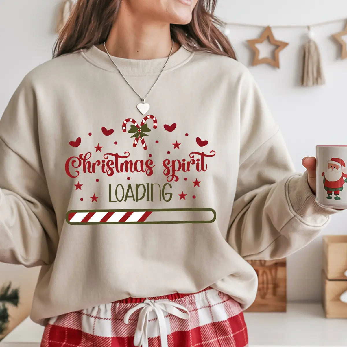 Sand-colored sweatshirt with “Christmas Spirit Loading” DTF design featuring red hearts, candy cane bow, and festive progress bar.
