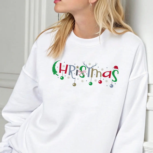 White sweatshirt with colorful “Christmas” DTF design featuring ornaments, stars, antlers, and Santa hat accents.