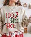Beige sweatshirt with “Ho Ho Ho” red and green Gothic Christmas DTF design, featuring candy cane, holly leaves, and small skull accents.