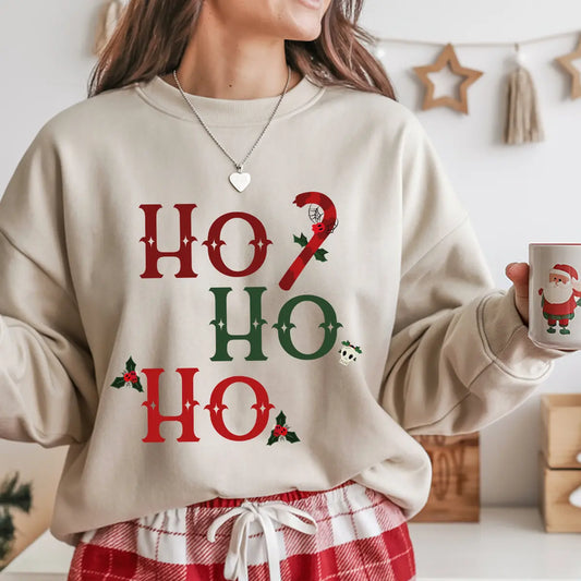 Beige sweatshirt with “Ho Ho Ho” red and green Gothic Christmas DTF design, featuring candy cane, holly leaves, and small skull accents.