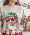 Sand-colored sweatshirt with “Family Is the Greatest Christmas Gift” festive DTF design in red, green, and navy with holly leaf accents.