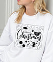 White sweatshirt with “Merry Christmas” DTF design featuring a Santa hat, cocoa mug, ornaments, and stocking outlined in a festive frame.