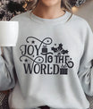 Gray sweatshirt with “Joy to the World” Christmas design featuring holly leaves, stars, and gift icons.