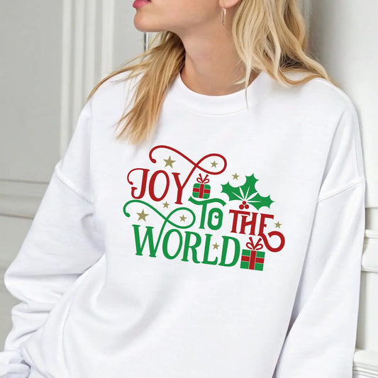 White sweatshirt with “Joy to the World” design in red and green text, decorated with holly leaves, gold stars, and gifts.