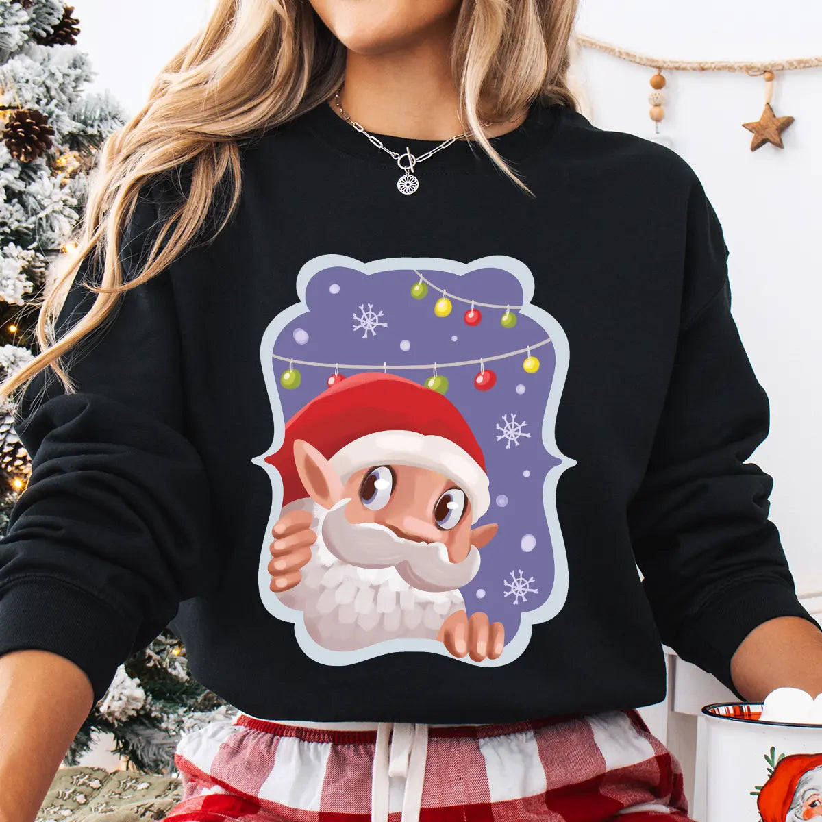 Black sweatshirt with a cute cartoon Santa peeking out against a snowy purple background with colorful lights.