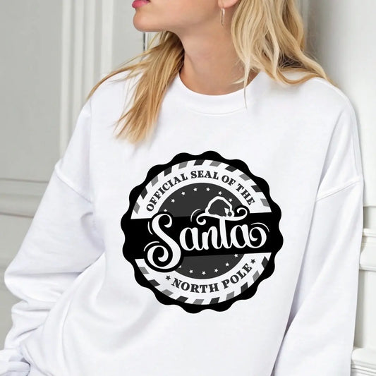 White sweatshirt featuring a black and white circular “Official Santa Seal of the North Pole” DTF transfer design.