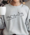 Grey sweatshirt with minimalist black outline DTF transfer showing Santa’s sleigh and three flying reindeer.