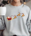 Grey sweatshirt with a colorful DTF transfer of Santa in a red sleigh pulled by three reindeer in flight.