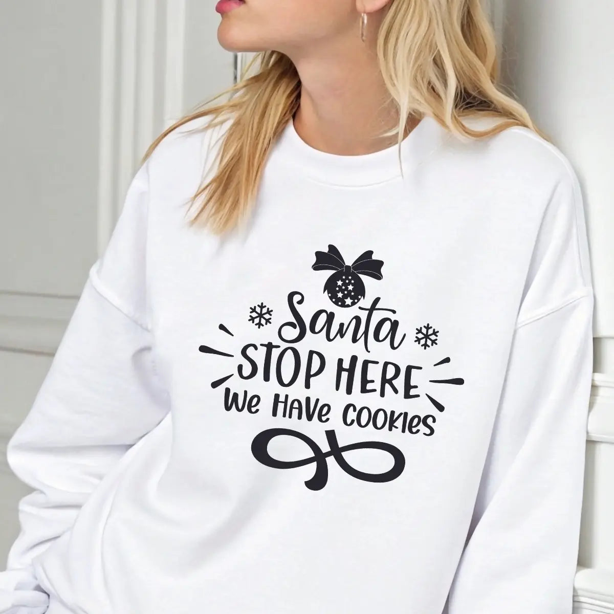 White sweatshirt with black “Santa Stop Here We Have Cookies” DTF design featuring snowflakes and an ornament.