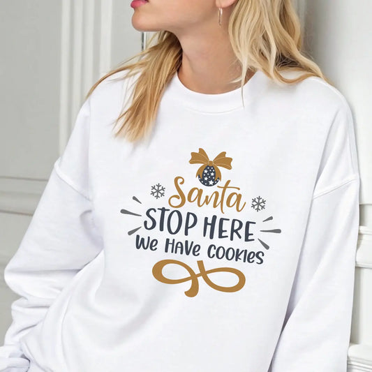 White sweatshirt with “Santa Stop Here We Have Cookies” DTF design in gold and black featuring an ornament and snowflakes.