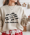Sand-colored sweatshirt with “Late Delivery” DTF design showing Santa’s sleigh surrounded by cars in traffic.
