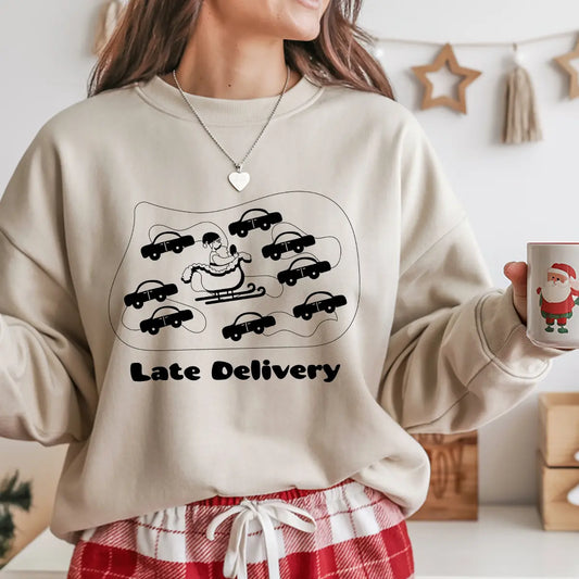 Sand-colored sweatshirt with “Late Delivery” DTF design showing Santa’s sleigh surrounded by cars in traffic.