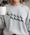 Grey sweatshirt featuring minimalist black reindeer silhouettes in flight, simple and elegant Christmas DTF transfer design.