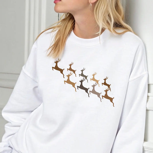 White sweatshirt with gold, bronze, and taupe reindeer silhouettes in flight, elegant gradient DTF transfer design for Christmas apparel.