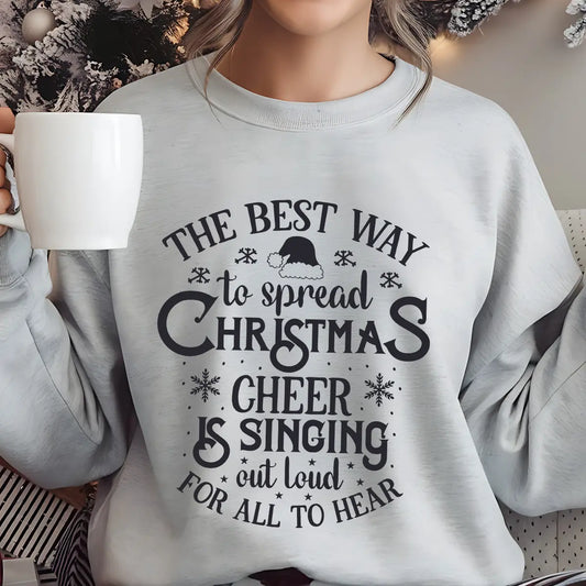 Grey sweatshirt with “The Best Way to Spread Christmas Cheer is Singing Out Loud for All to Hear” text design and Santa hat accent – festive holiday DTF print.