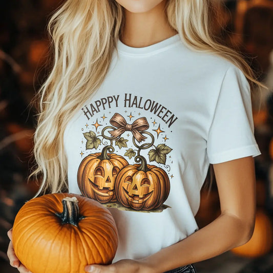 White t-shirt with two smiling jack-o’-lanterns tied with a bow and “Happy Halloween” text in vintage style, perfect for fall and Halloween outfits.