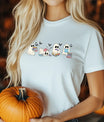 White t-shirt with four cute reading ghosts and flying bats—Bookish Halloween DTF transfer for cozy fall readers.