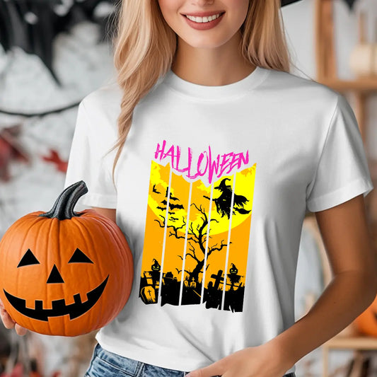 White T-shirt with bright orange and yellow Halloween DTF transfer featuring a witch flying over a graveyard and pink Halloween text.