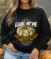 Black sweatshirt featuring “Look At Me” Halloween DTF design with creepy glowing pumpkins and spooky jack-o’-lantern faces.