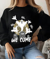 Black sweatshirt featuring “We Come” Halloween DTF design with glowing ghosts, gravestones, and a moon background.