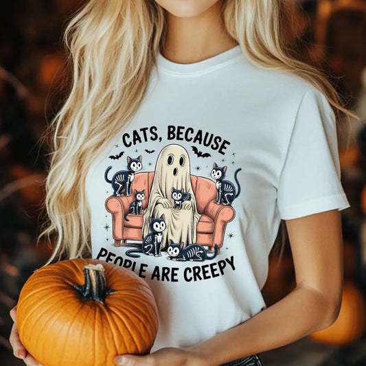 White t-shirt with “Cats Because People Are Creepy” DTF transfer featuring a ghost sitting on a couch surrounded by cute skeleton cats in a Halloween theme.