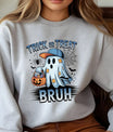 Gray sweatshirt with “Trick or Treat Bruh” DTF transfer showing a cartoon ghost wearing a cap and holding a pumpkin bucket with candies in a Halloween design.