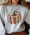 Gray sweatshirt with a pumpkin made of stacked books and green vines, cozy fall DTF transfer design for book lovers.