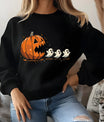 Black sweatshirt with Halloween design of a jack-o’-lantern chasing three cute ghosts, funny fall DTF transfer.
