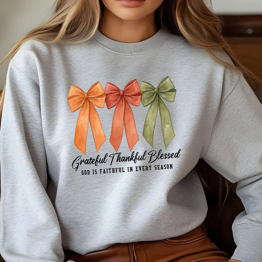 Gray sweatshirt with three fall-colored bows and text “Grateful Thankful Blessed – God is faithful in every season.”