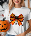 White t-shirt with orange and black spiderweb bow design featuring a hanging spider, perfect for Halloween-themed outfits.