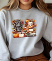 Grey sweatshirt with a fall-themed DTF design featuring a cute pumpkin character, books, flowers, and the text “Just a Girl Who Loves Fall.”