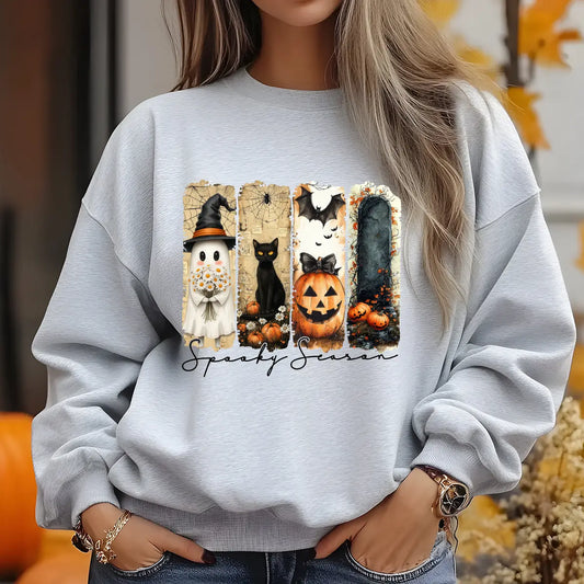Grey sweatshirt featuring a Halloween-themed DTF transfer with a ghost, black cat, pumpkin, bat, and “Spooky Season” text in warm fall colors.