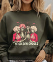 Green sweatshirt with three skeleton women in vintage hairstyles and red outfits, with the text “The Golden Ghouls” in cream lettering.