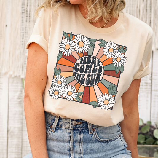 Here Comes the Sun DTF transfer design on a t-shirt with retro sun rays and daisies, ideal for summer vibes.